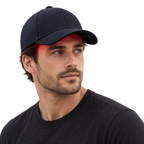 Front three-quarter view of a man wearing the Hair Cap with a red light glow beneath the brim