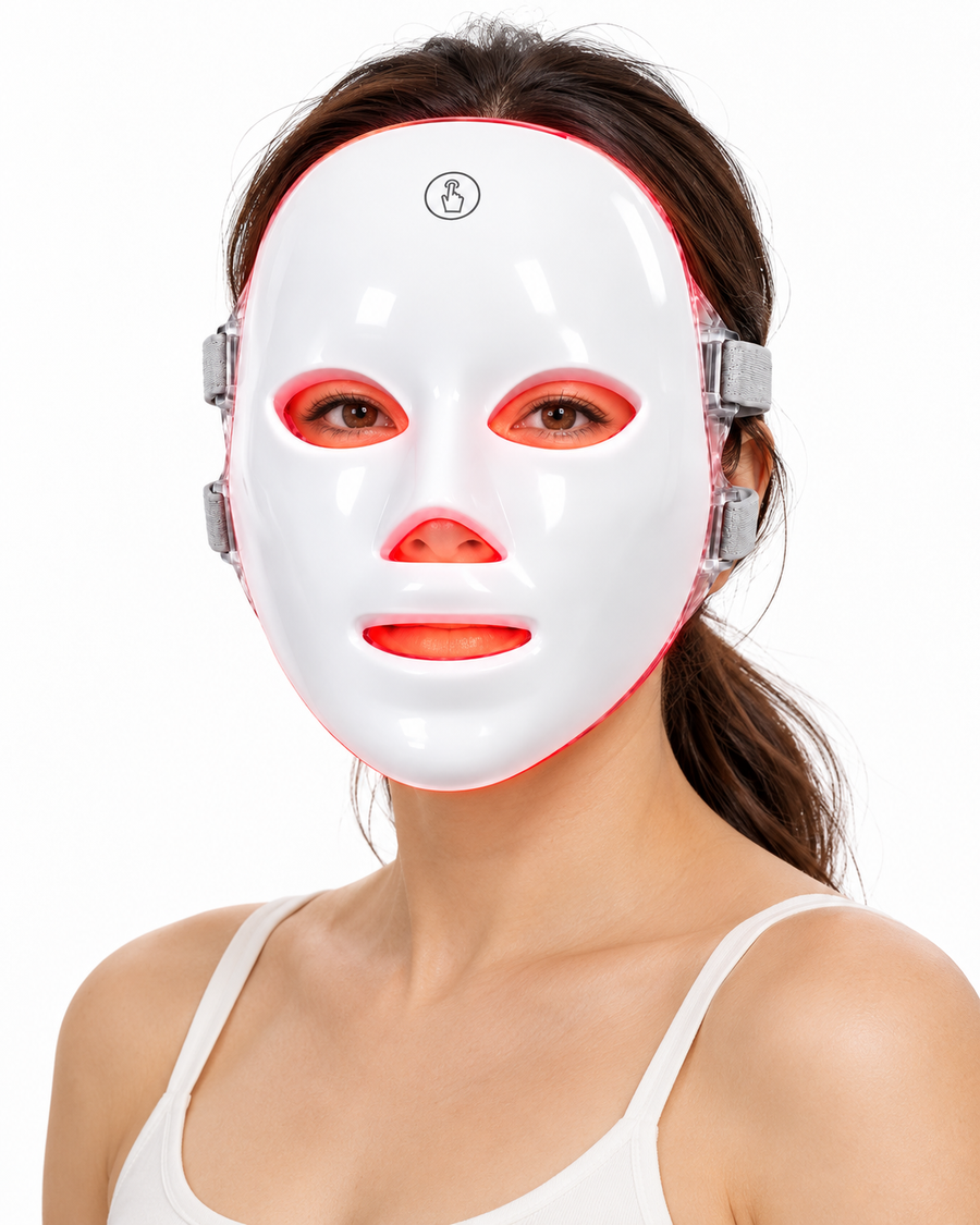 Woman wearing the Red Light Therapy Mask with red light visible around its eye, nose and mouth openings