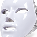 Tight angled close-up of the Red Light Therapy Mask showing its white shell, eye, nose and mouth openings and clear edge