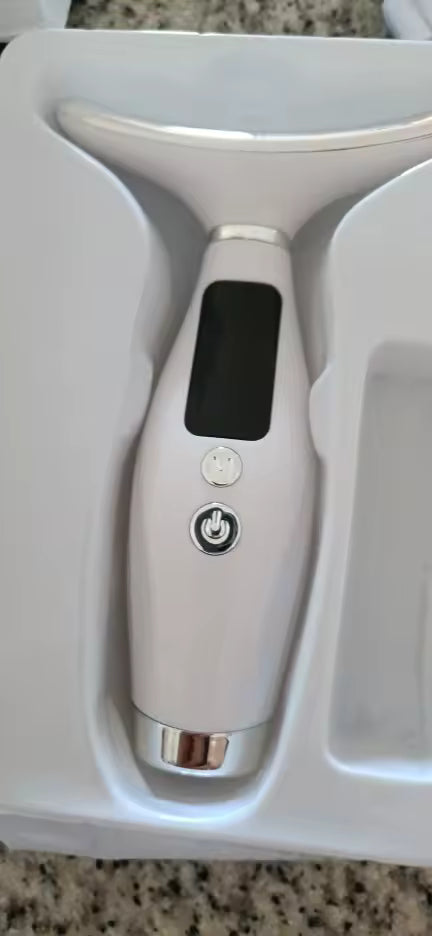 The wand resting in its packaging, showing the display and controls.